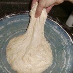 beginning at the top of your dough ball, stretch the dough then fold it over itself before moving on to the next stretch and fold.